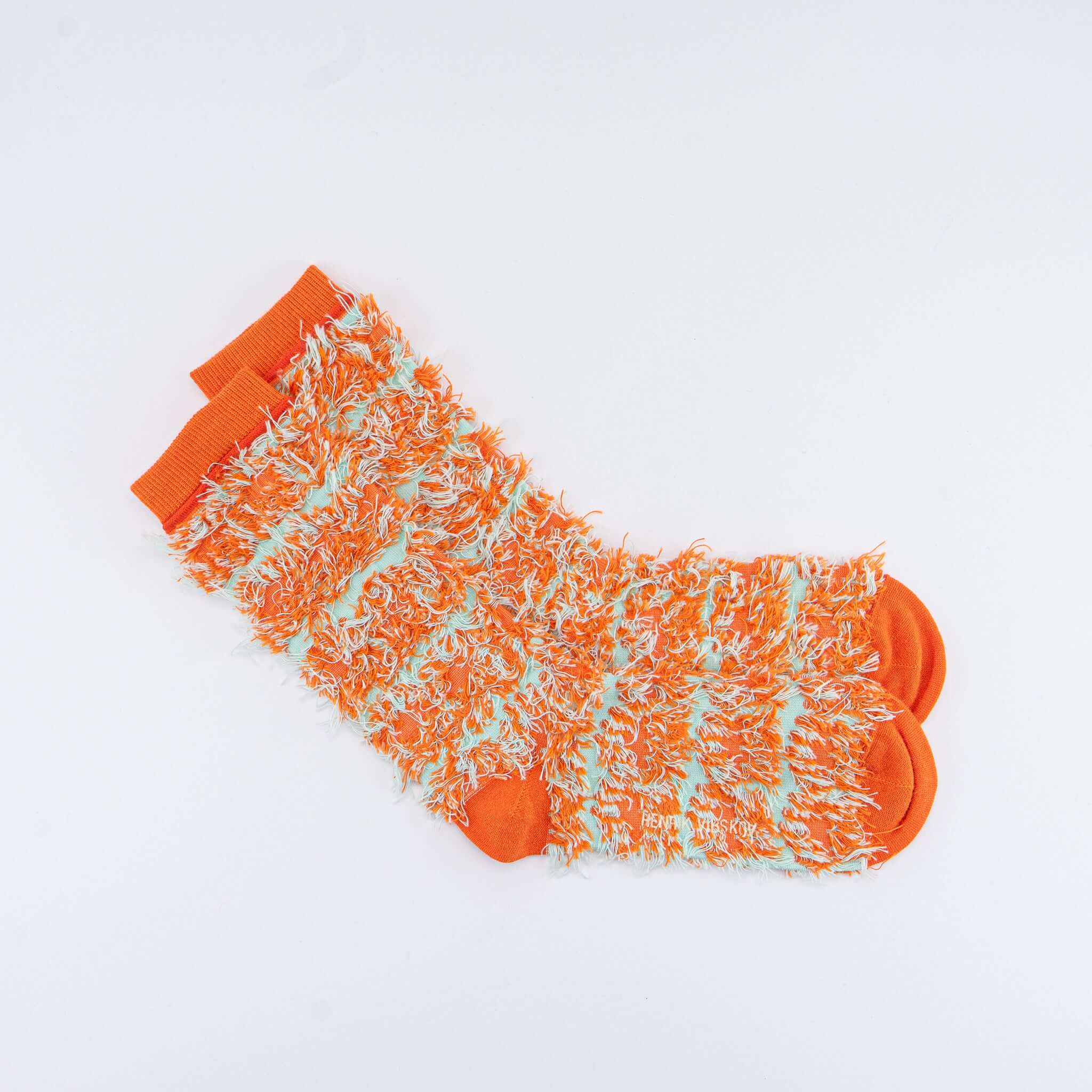 Designer Socken in leuchtendem Orange und Mint mit fuzzy Textur, ideal für einen stilvollen skandinavischen Look.